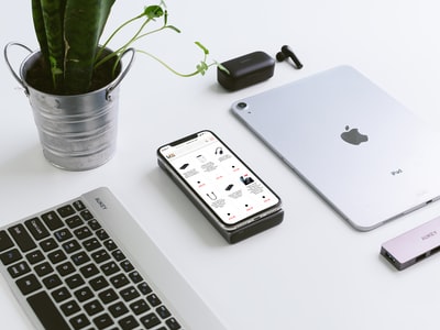 银色ipad旁边的苹果魔术键盘和苹果魔术鼠标